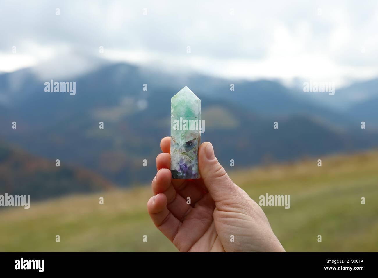 Femme tenant le magnifique cristal dans les montagnes, gros plan Banque D'Images