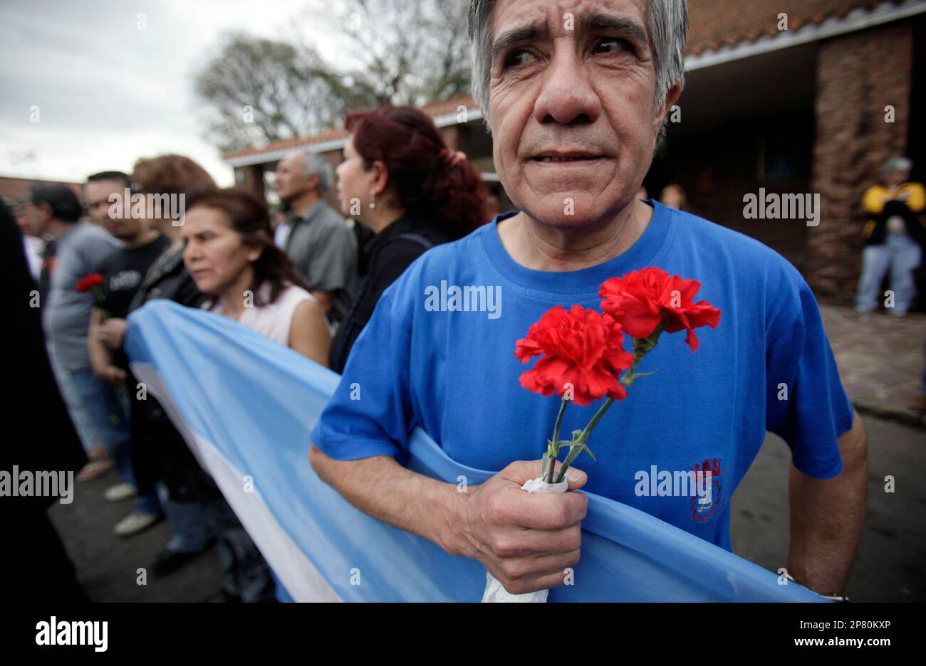 A fan of Argentina's late folk singer Mercedes Sosa holds flowers during her funeral in Buenos Aires, Monday, Oct. 5, 2009. Sosa, the "voice of Latin America" whose music inspired opponents of South America's brutal military regimes and led to her forced exile in Europe, died on Sunday at the age of 74. (AP Photo/Natacha Pisarenko) Banque D'Images