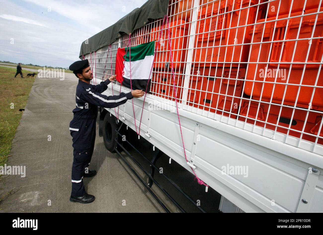 A member od rescue team of United Arab Emirates put on a national flag on the truck carrying their equipment upon arrival at Minangkabau International Airport in Padang, West Sumatra, Indonesia, Saturday, Oct. 3, 2009. Wednesday's 7.6 magnitude temblor devastated a stretch of more than 60 miles (100 kilometers) along the western coast of Sumatra island. (AP Photo/Dita Alangkara) Banque D'Images