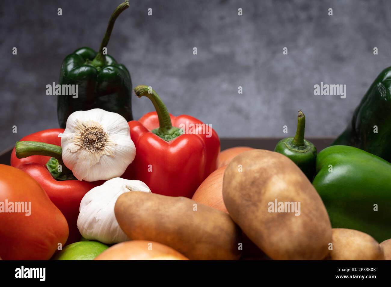 Une pile d'ingrédients frais et sains de la ferme à la table, poivrons, tomates, pommes de terre, oignon, et de l'ail Banque D'Images