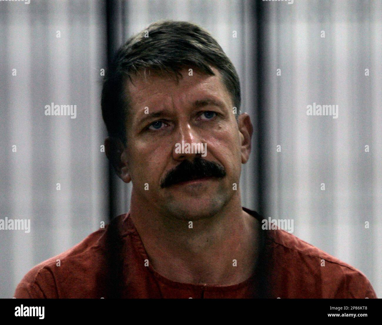 Alleged Russian arms dealer Viktor Bout looks out from inside the detention room at a criminal court in Bangkok, Thailand, Tuesday, Aug. 11, 1009. The Thai court is expected to rule Tuesday on whether to send an alleged Russian weapons smuggler, once dubbed the "Merchant of Death," to face trial in the United States. (AP Photo/Apichart Weerawong) Banque D'Images
