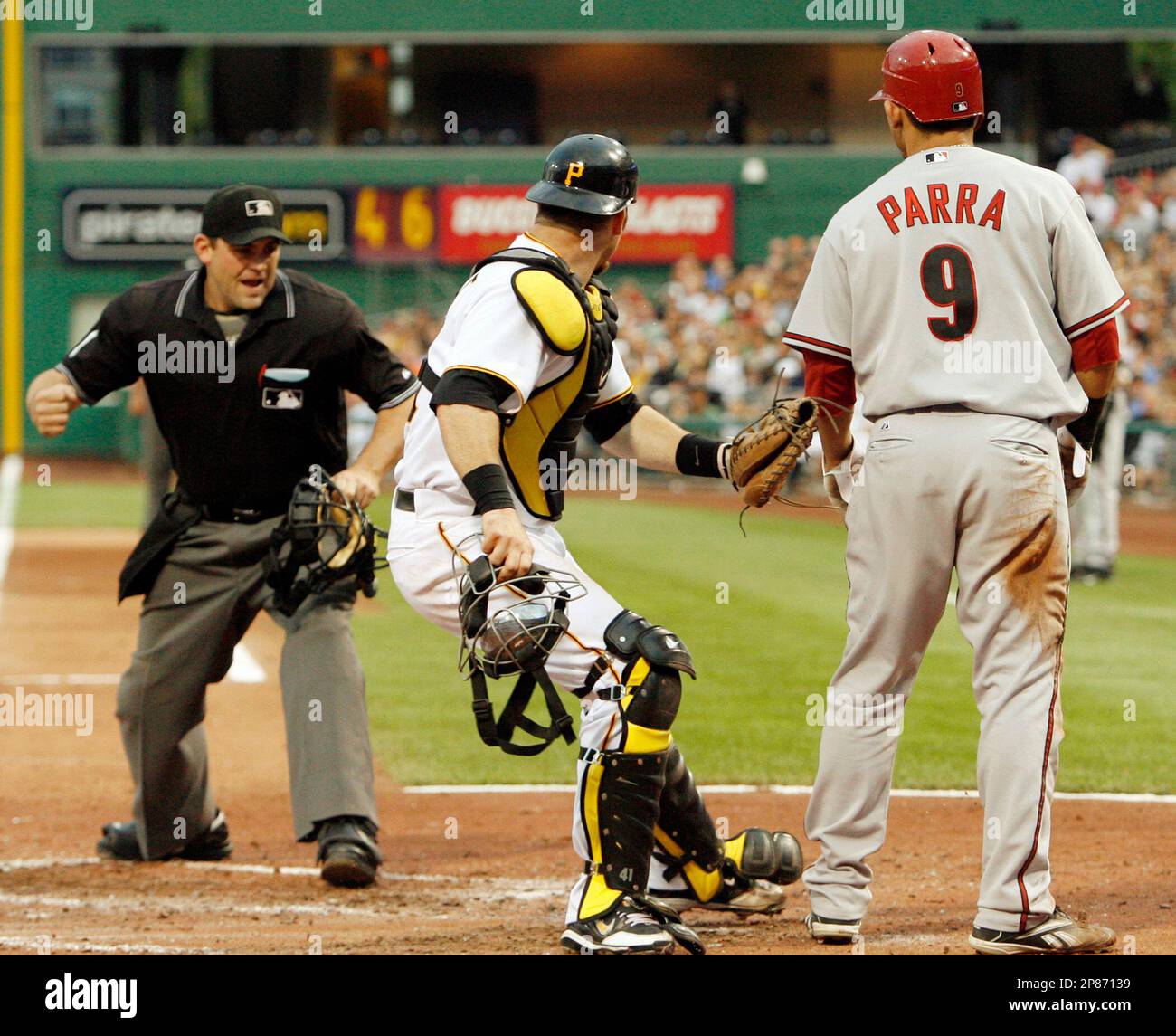 Pittsburgh Pirates catcher Ryan Doumit, center, looks as home plate umpire Brian Knight, left, calls Arizona Diamondbacks' Garardo Parra, right, out after he tried to score from first base on a double by Mark Reynolds in the third inning inning of the baseball game in Pittsburgh, Thursday, Aug. 6, 2009. No call was made on the initial play, but Parra was called out after Doumit tagged him. (AP Photo/Keith Srakocic) Banque D'Images