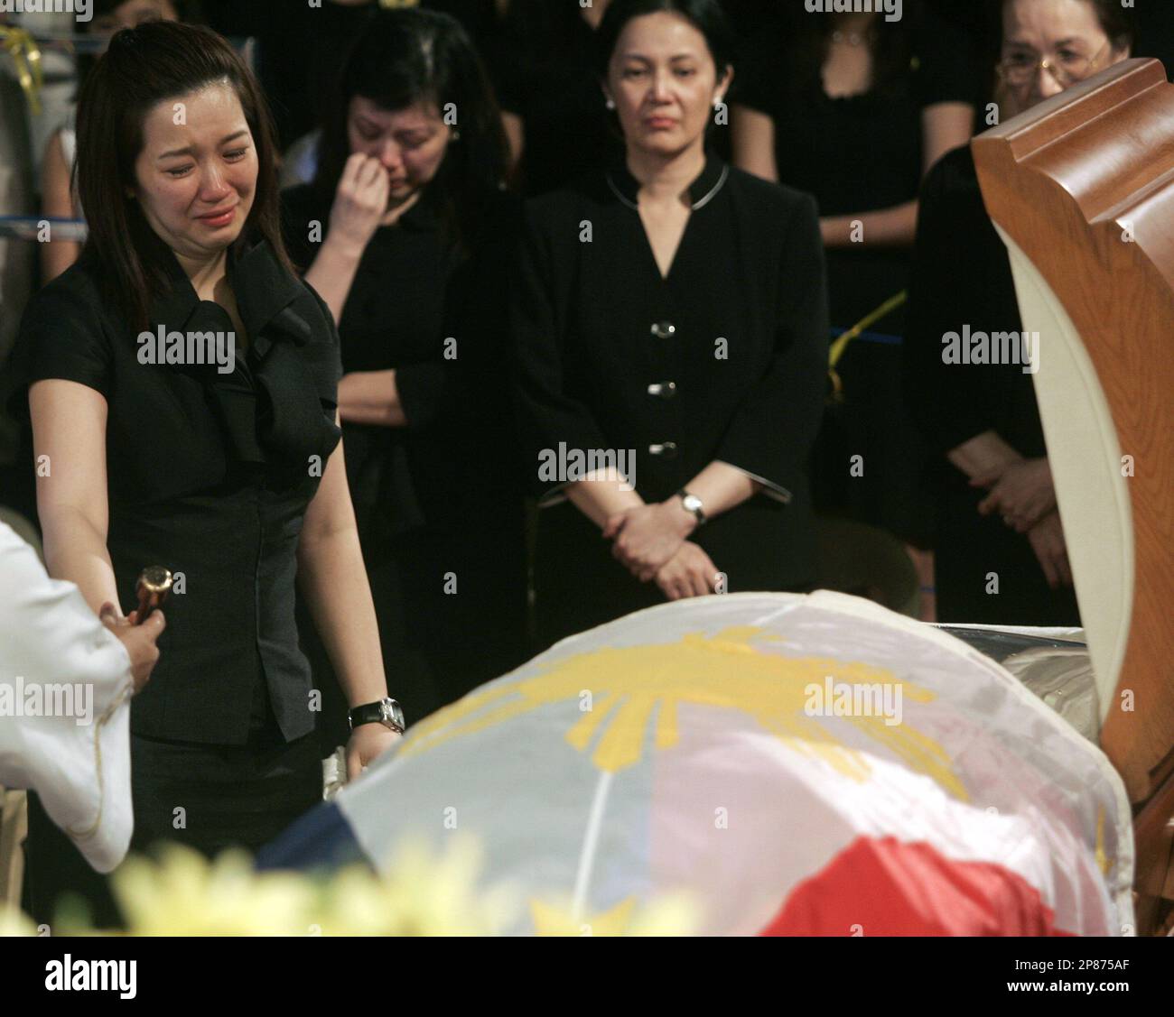 A grieving Kris Aquino, the youngest daughter of former Philippine  President Corazon "Cory" Aquino prepares to sprinkle Holy Water on her  mother's casket during interment rites at Manila Memorial Park at suburban