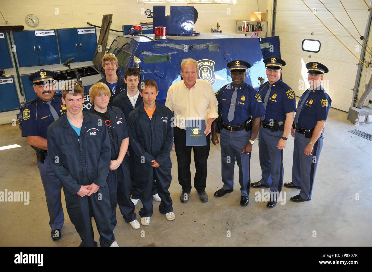 Anchor Bay students meet with representatives from the Michigan State Police headquarters and Richmond post to show off the work done by the students to get a light armored vehicle back in working order. With teacher Dan Campbell are, on the right, from left, State Police officers Capt. Harold Love, Lt. Dave Bower, Inspector Dan Bateman. At the left is Lt. Rob York (commander of the Richmond Post). (AP Photo/Macomb Daily, David N. Posavetz) Banque D'Images