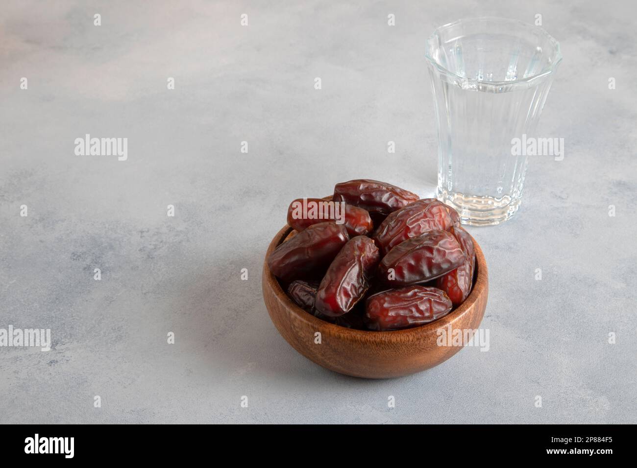 Verre d'eau, datez les fruits sur fond clair Banque D'Images