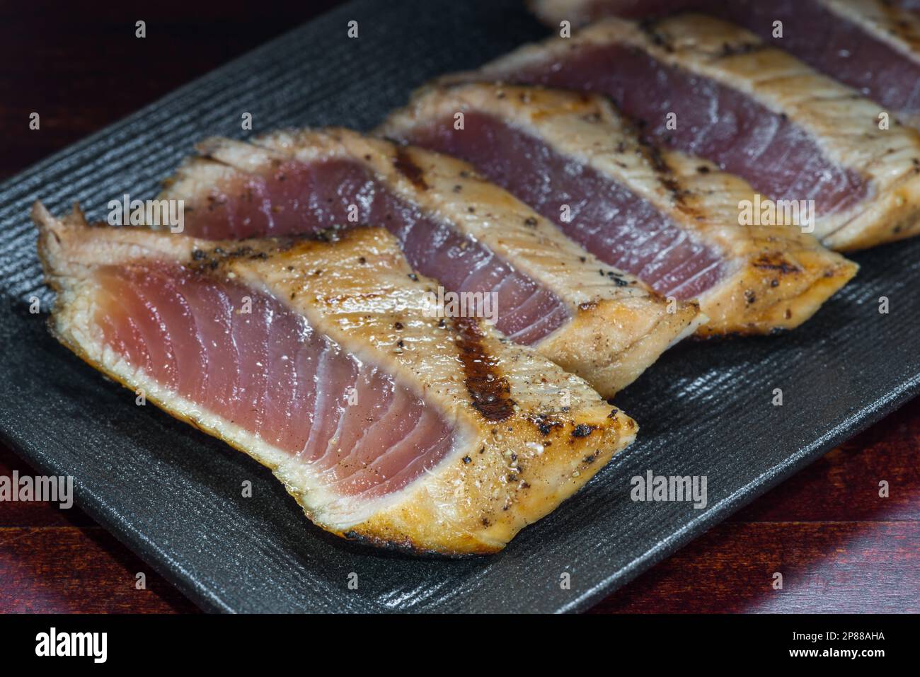 Style japonais de temaki avec filet de maquereau sur plaque noire, cuisine asiatique, cuisine japonaise traditionnelle, gros plan. Banque D'Images