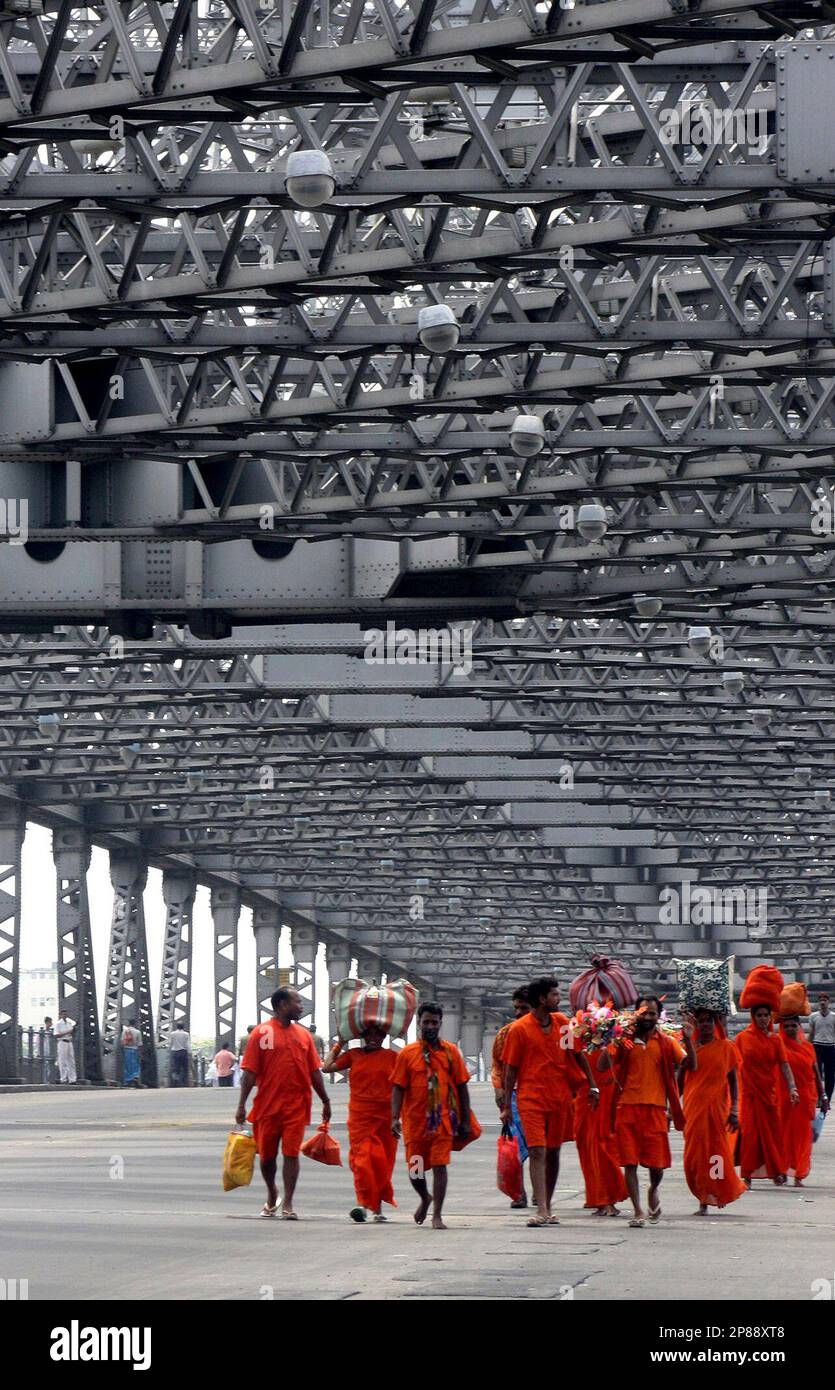 Hindu pilgrims walk on a deserted Howrah Bridge during a 12-hour general strike called by the party in Calcutta, India, Friday, July 17, 2009. Normal life was thrown out of gear across West Bengal state with rail and road traffic severely affected following the strike called to protest the alleged attack on a Congress Legislature Party (CLP) team at Mangalkot, some 100 kilometers (62 miles) north of Calcutta on Wednesday. (AP Photo/Sucheta Das) Banque D'Images