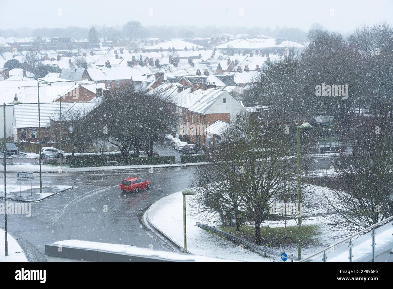 Une lourde neige tombant sur Basingstoke lorsqu'une voiture se déplace autour du rond-point Victory, après une période froide le 8th mars 2023. ROYAUME-UNI Banque D'Images