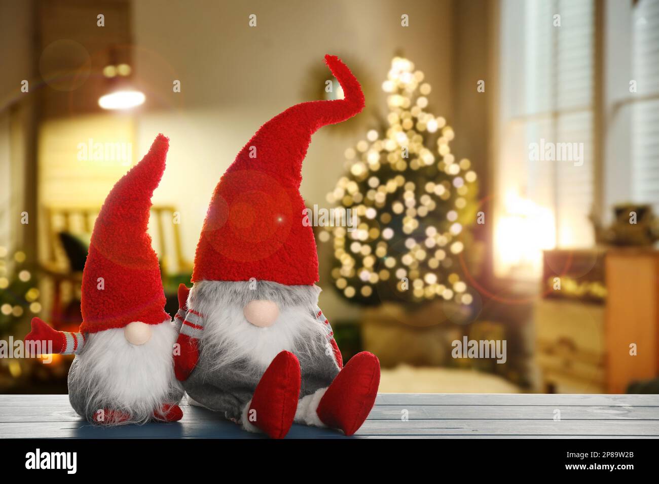 Nains de Noël amusants sur table en bois bleu dans la chambre avec des décorations de fête. Espace pour le texte Banque D'Images