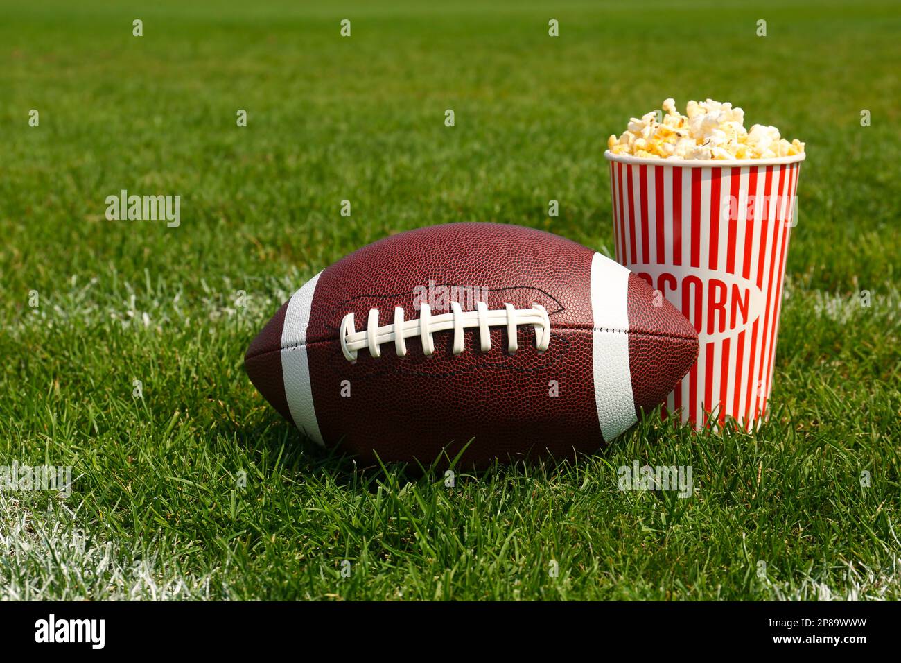 Ballon de football avec pop-corn et tasses sur table en bois gris Photo  Stock - Alamy