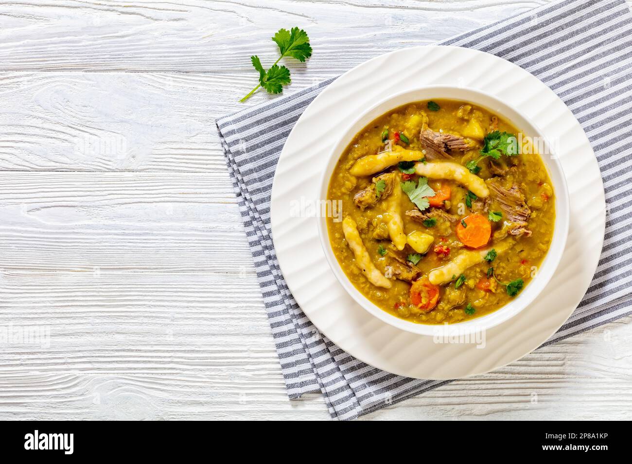 petits pois, soupe de petits pois avec boulettes, légumes et bœuf dans un bol blanc sur table en bois blanc, cuisine jamaïcaine, plat, espace libre Banque D'Images