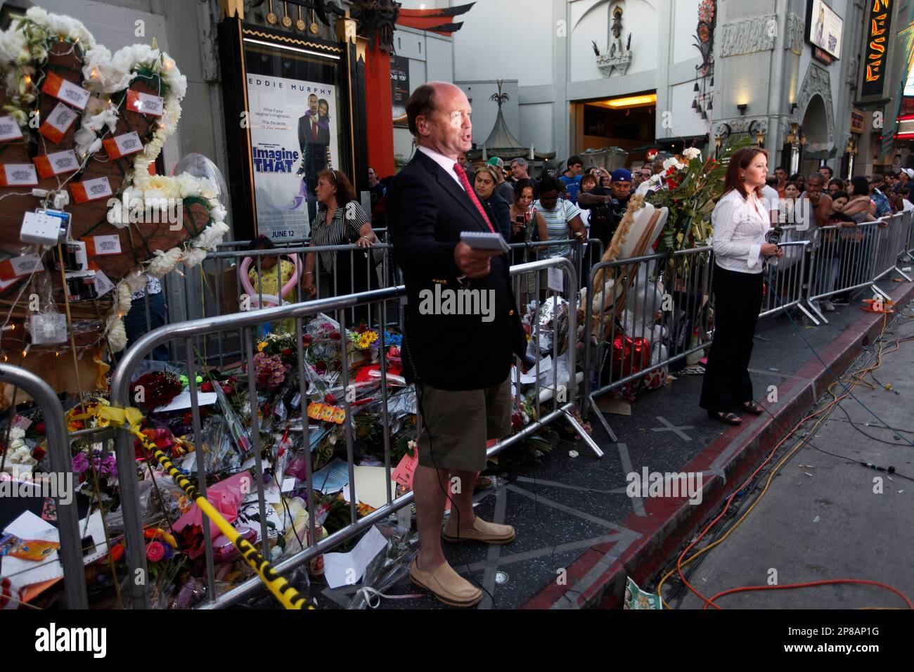 Television crews do their evening stand ups in front of the sidewalk shrine at the star of Michael Jackson as fans file past, rear, on the Hollywood Walk of Fame in Los Angeles, Sunday, June 28, 2009. (AP Photo/Charles Dharapak) Banque D'Images