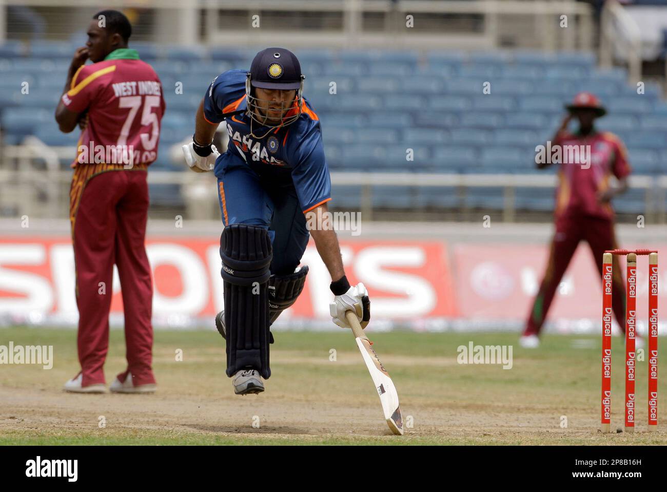 India's batsman Yuvraj Singh, right, makes his grounds to score a century, as West Indies' bowler Jerome Taylor looks to the outfield during their first one-day international cricket match at Sabina Park, in Kingston, Jamaica, Friday, June 26, 2009. (AP Photo/Andres Leighton) Banque D'Images
