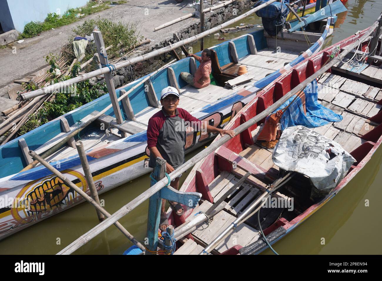 pêcheur sur un bateau traditionnel en bois prêt à faire la voile pour pêcher par une journée ensoleillée Banque D'Images
