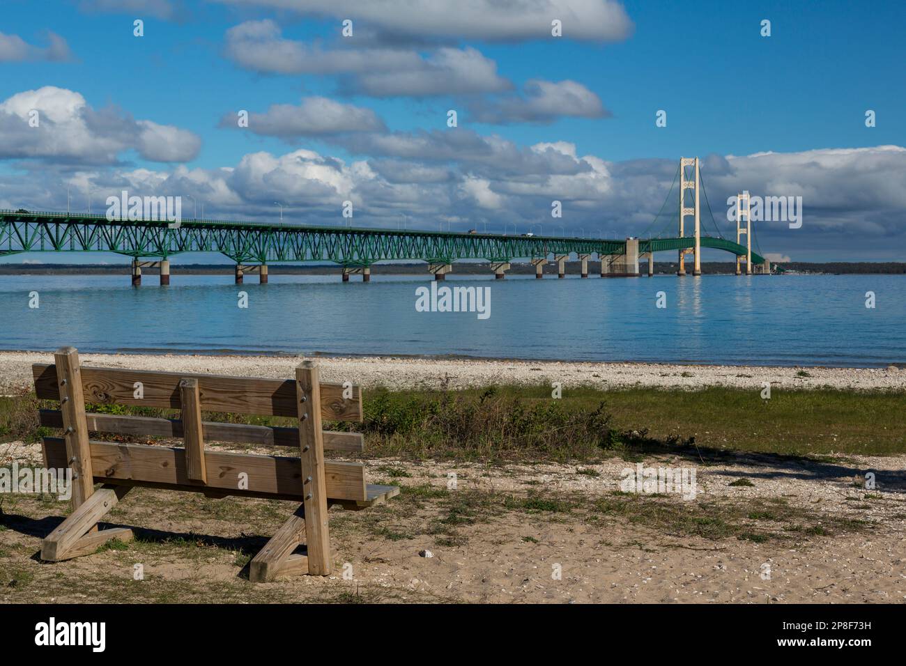 Un long pont suspendu avec banc de stationnement en premier plan. Banque D'Images