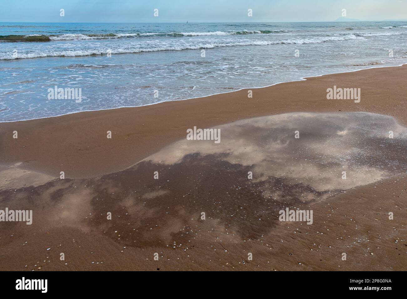Mar y charco de agua en la playa con el reflejo de las nubes Banque D'Images