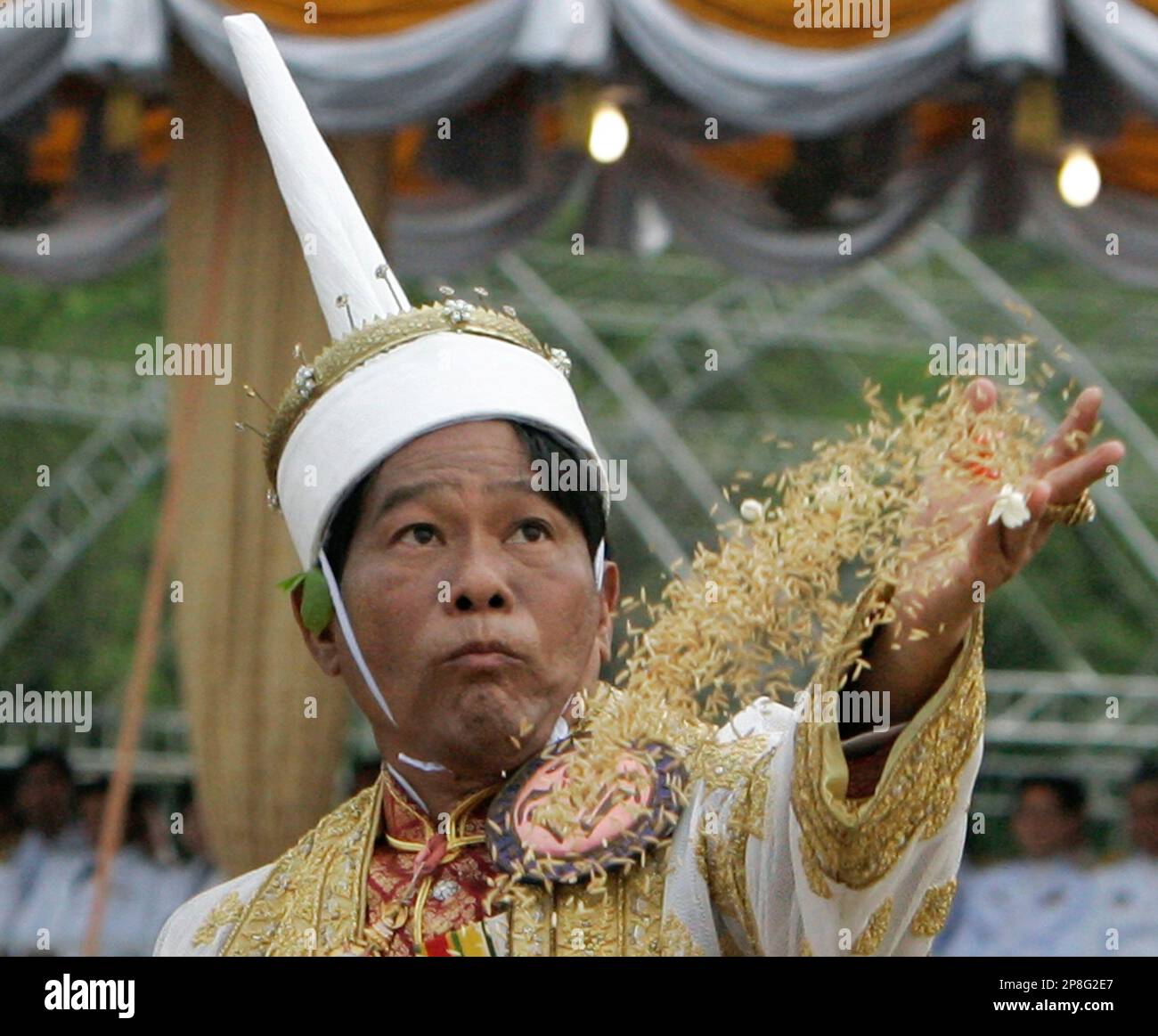Thailand Secretary of Agriculture Jaranthada Kanasut scatters sacred seed rice during royal ploughing ceremonies Monday, May 11, 2009, in Bangkok, Thailand. The annual event marks the beginning of the rice growing season. (AP Photo/Sakchai Lalit) Banque D'Images