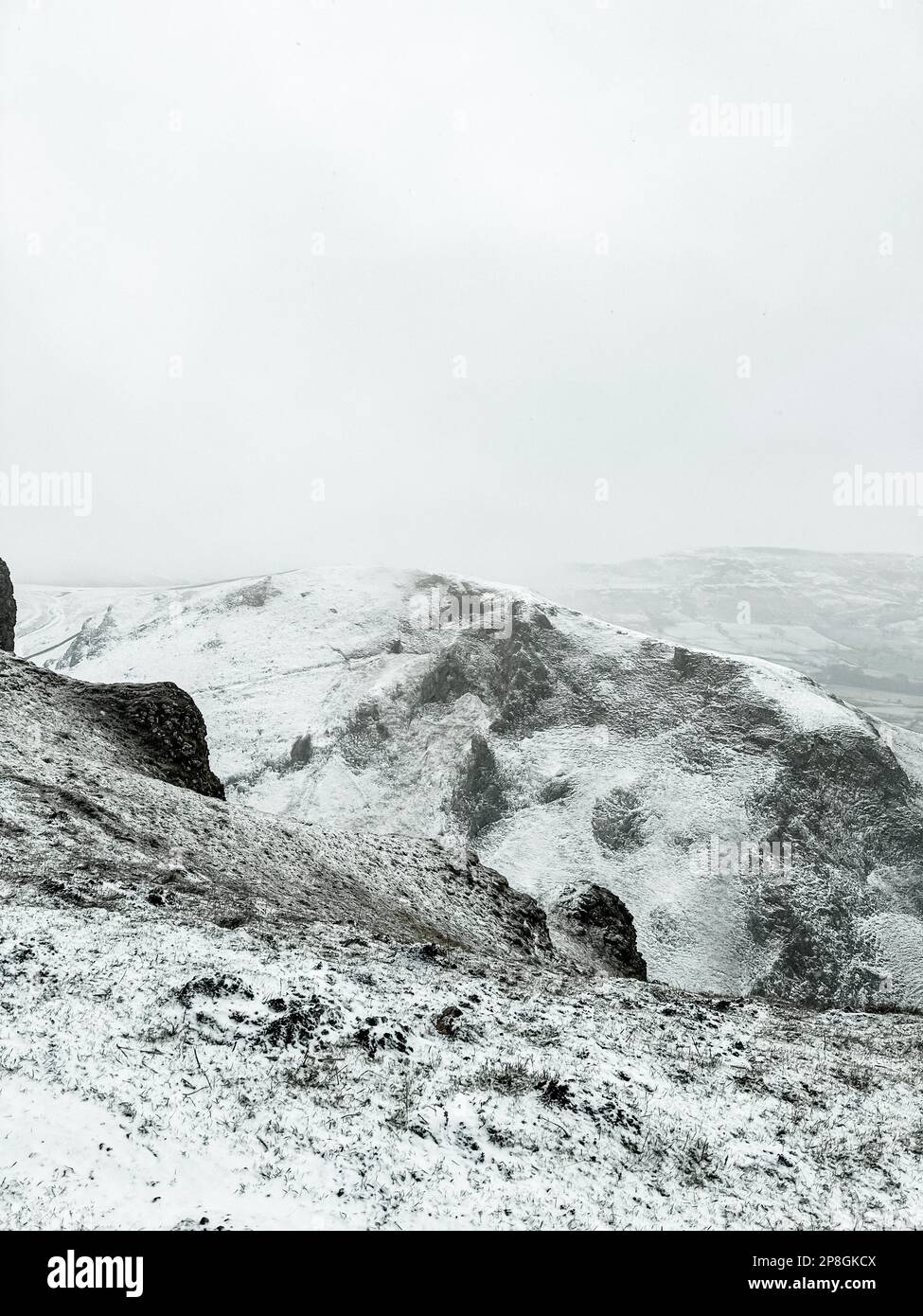 Montagne rocheuse enneigée sur Winnat's Pass lors d'une journée nuageuse dans le Peak District, en Angleterre Banque D'Images