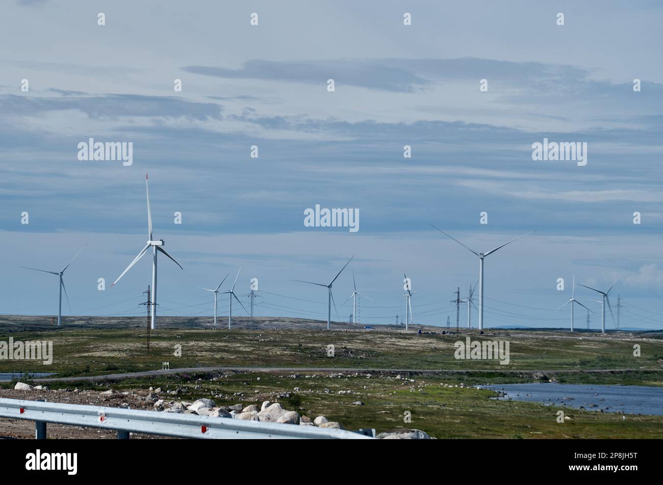 Ferme éolienne dans une zone vallonnée sous ciel nuageux Banque D'Images