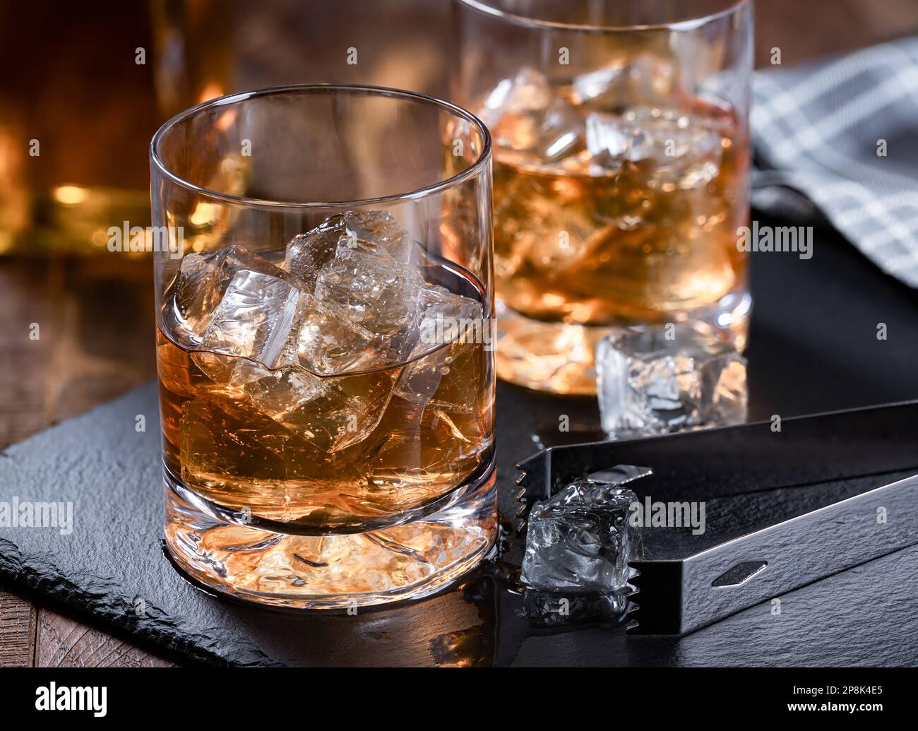 Deux verres de whisky avec glace sur un tableau noir en ardoise avec fond en bois Banque D'Images