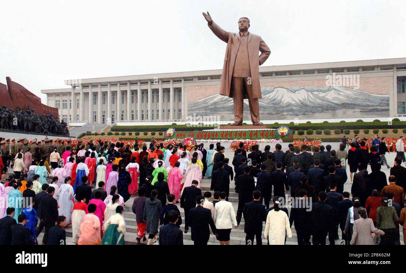 In this Korean Central News Agency photo released by Korea News Service in Tokyo, North Korean gather around the statue of late founding father Kim Il Sung to lay flowers, marking his 97th birthday, on Wednesday, April 15 2009 in Pyongyang, North Korea. North Korea celebrated Kim's birthday Wednesday amid international censure over the regime's threats to restart its nuclear program, expel U.N. inspectors and quit international disarmament talks. (AP Photo/Korean Central News Agency via Korea News Service) ** SOUTH KOREA OUT ** Banque D'Images