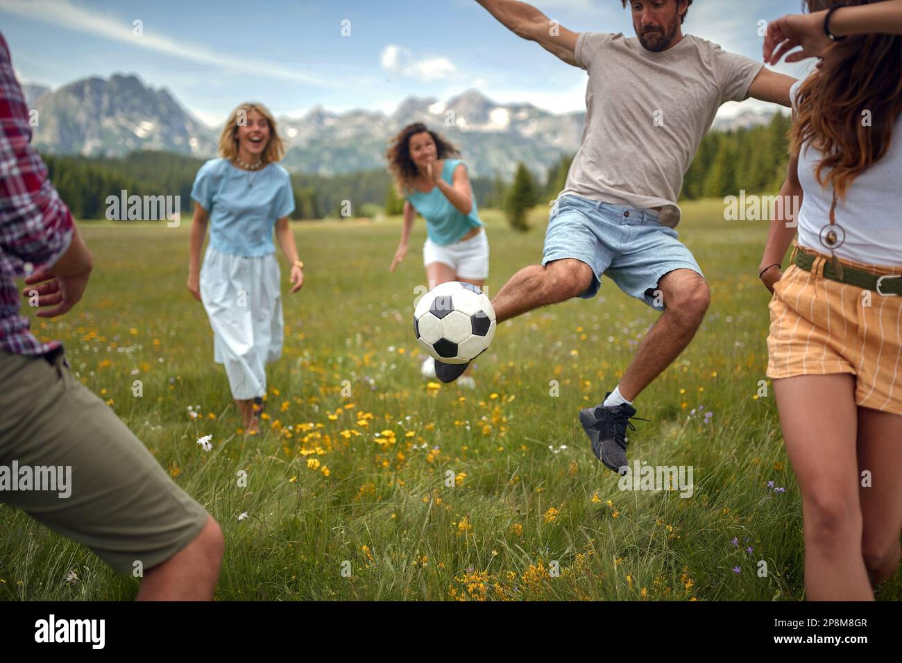 les gens jouant au ballon dans la nature à prairie. moment couth en mouvement Banque D'Images