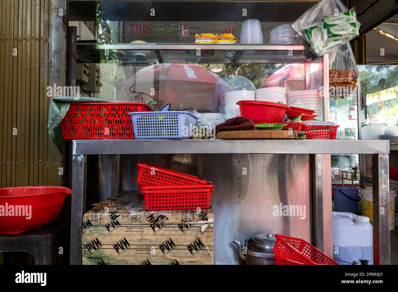 Paniers en plastique dans la cuisine en plein air d'un restaurant de rue à Ho Chi Minh ville, Vietnam. Banque D'Images