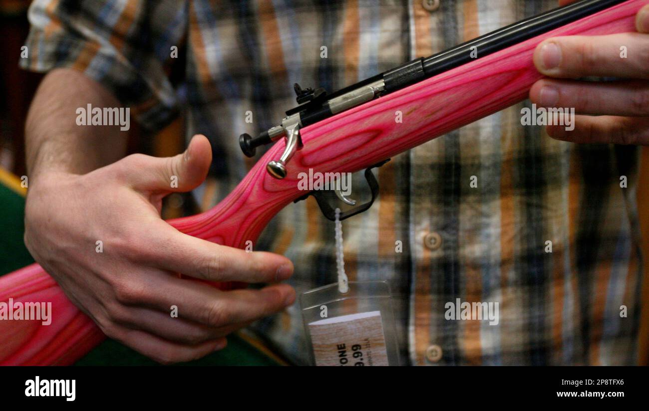 Sales associate David Jarasiewicz explains the single bolt action as he shows a pink .22 caliber youth model rifle in the gun department of the Sportsman's Warehouse in Ben Avon, Pa., Tuesday, March 3, 2009. In western Pennsylvania, where hunting is a popular tradition passed down for generations, guns are a way of life and an integral part of a culture that puts food on the table and makes people feel like they are one with nature.(AP Photo/Keith Srakocic) Banque D'Images