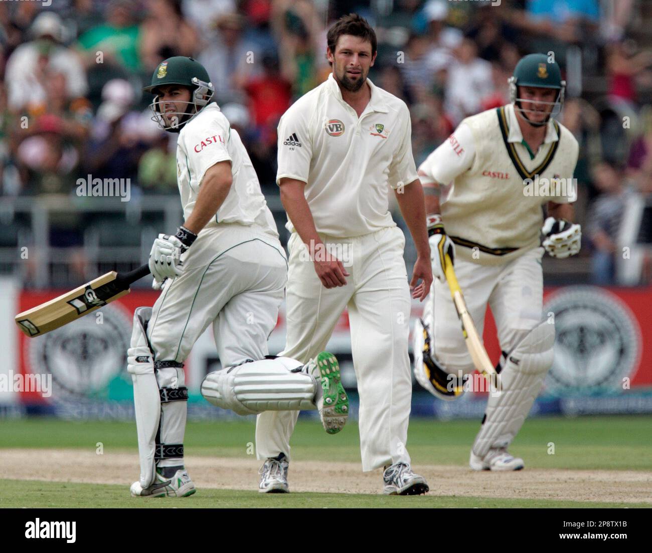South Africa's batsman Neil McKenzie, left, with captain Graeme Smith, right, run between the wickets as Australia's bowler Ben Hilfenhaus, center, looks on during the fourth day of the first test match at Wanderers stadium Johannesburg, South Africa, Sunday March 1, 2009. (AP Photo/Themba Hadebe) Banque D'Images