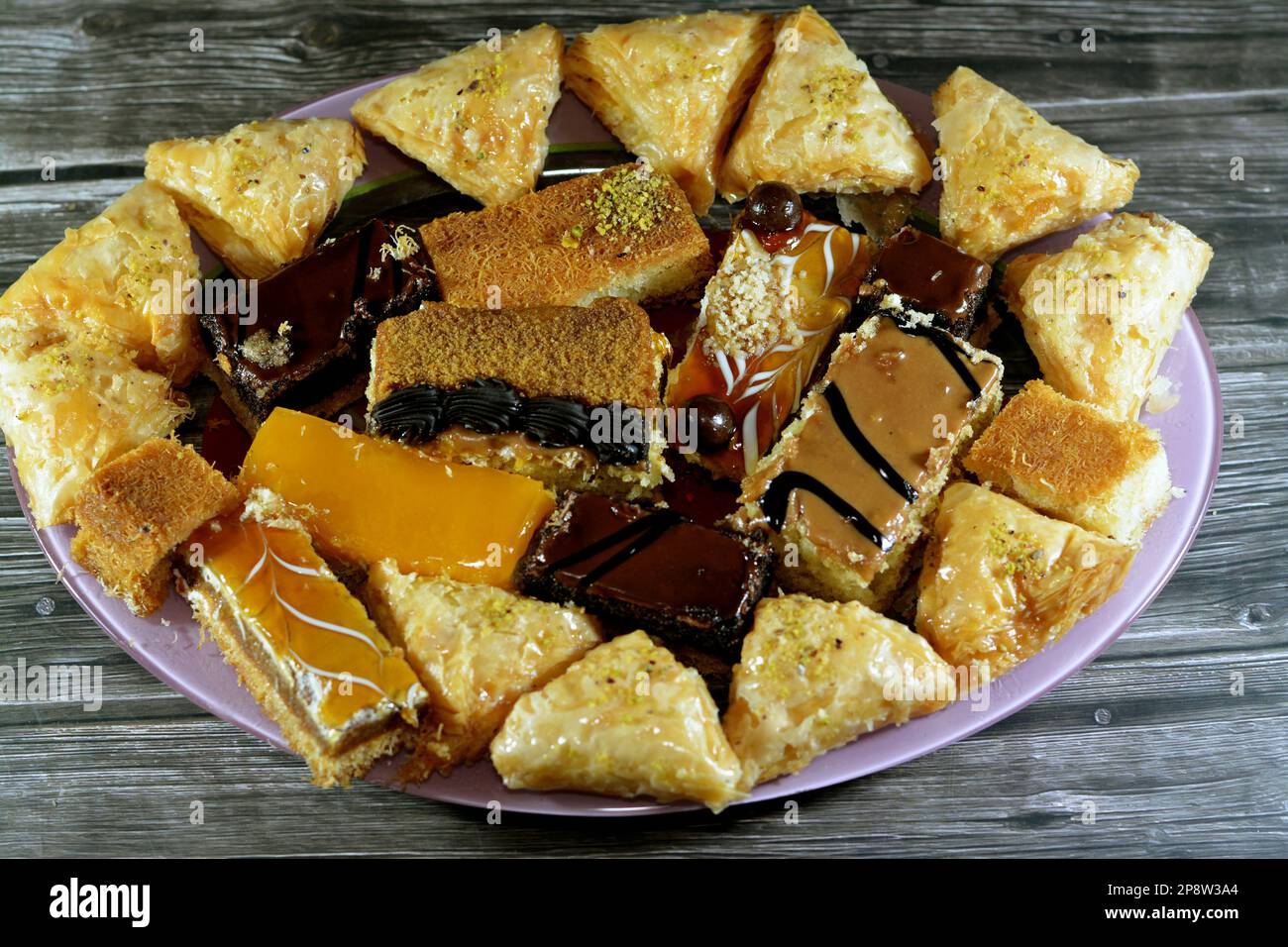Desserts du Ramadan oriental et pâtisseries de Konafa couvertes de compote de mangue, Kunafa farci de fromage crémeux, Konafa de crème fouettée au chocolat, Ba Banque D'Images