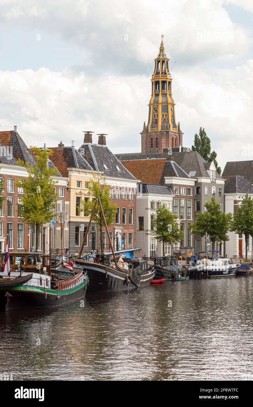 Navires historiques, maisons de canal et entrepôts sur le vieux port de Hoge der A avec la tour de l'église historique Der AA à Groningen. Banque D'Images