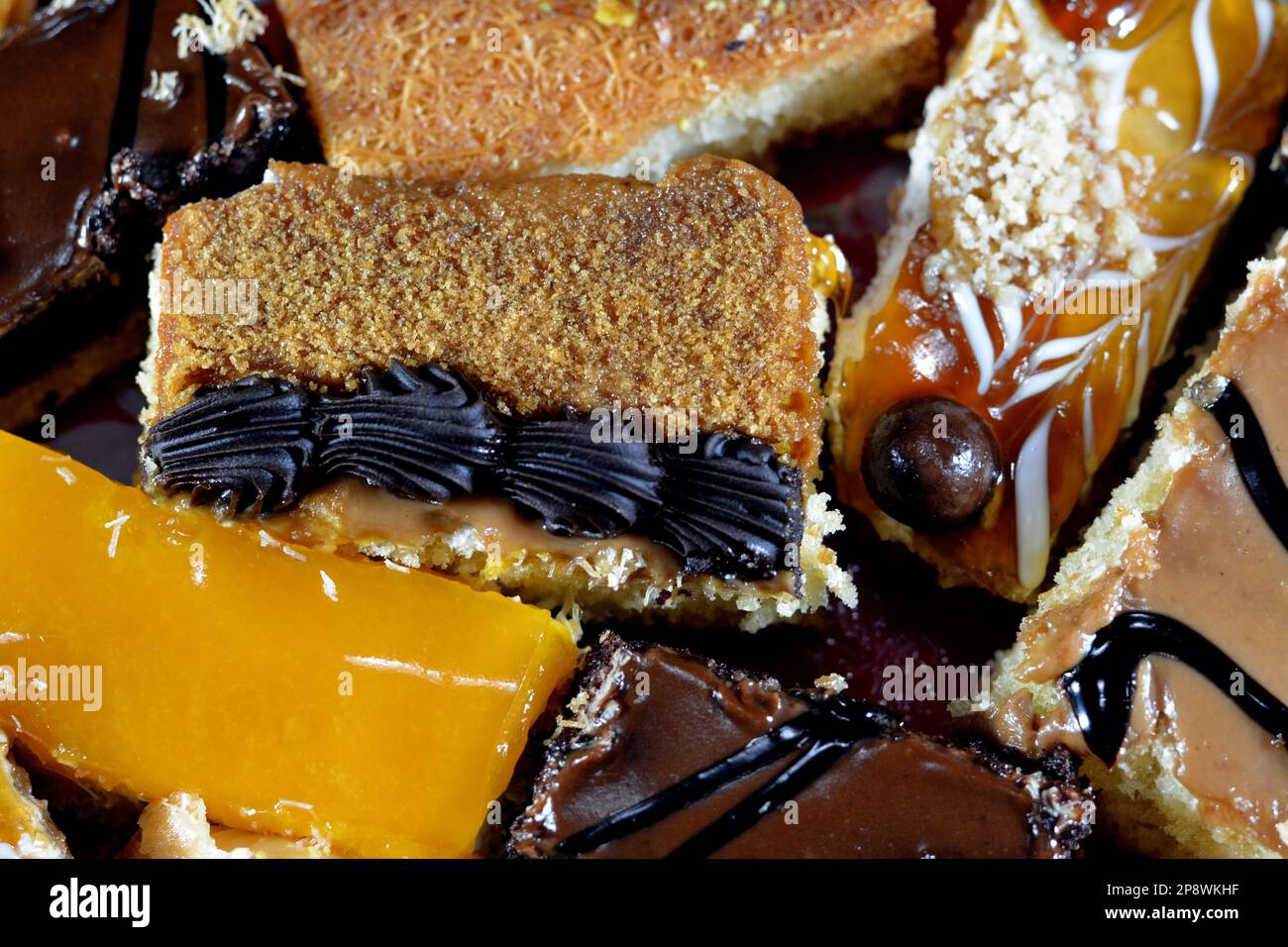 Desserts du Ramadan oriental et pâtisseries de Konafa couvertes de compote de mangue, Kunafa farci de fromage crémeux, Konafa de crème fouettée au chocolat, Ba Banque D'Images