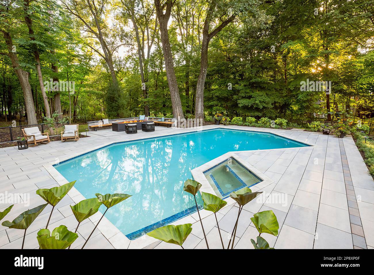 L'extérieur d'une maison rénovée avec de nouveaux aménagements paysagers, des plantations et une piscine Banque D'Images