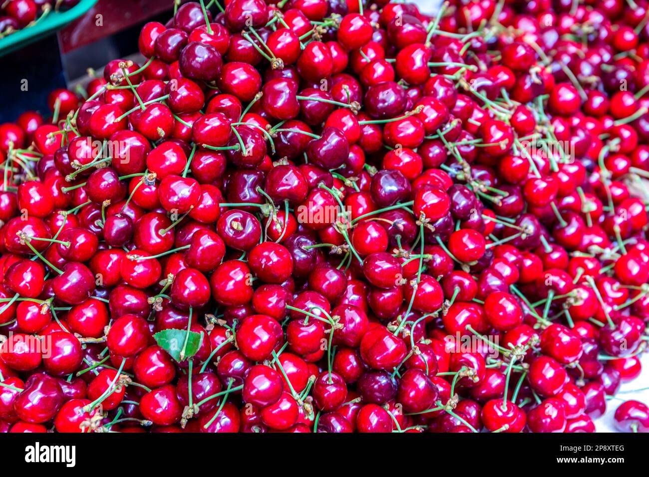 Beaucoup de cerises rouges avec des tiges, récoltées, sur le marché au marché central de Kutaisi (Green Bazaar, Mtsvane Bazari). Banque D'Images