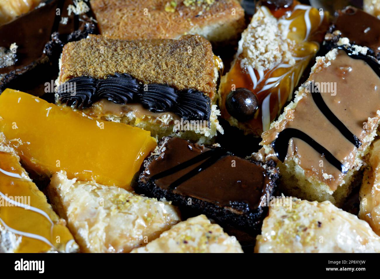 Desserts du Ramadan oriental et pâtisseries de Konafa couvertes de compote de mangue, Kunafa farci de fromage crémeux, Konafa de crème fouettée au chocolat, Ba Banque D'Images