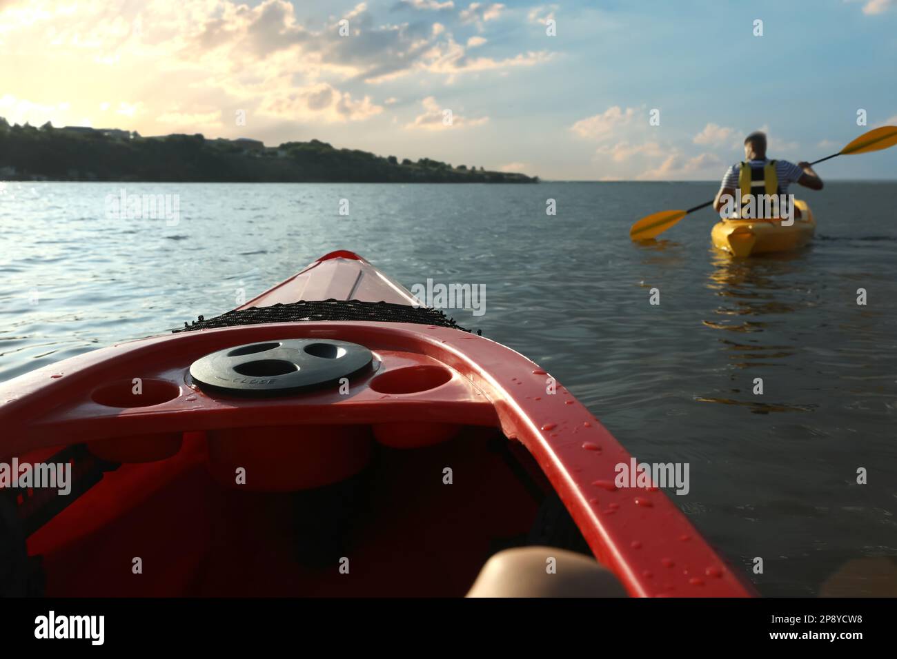 Homme dans la vie veste de kayak sur la rivière, vue de l'autre bateau. En été Banque D'Images Homme dans la vie veste de kayak sur la rivière, vue de l'autre bateau. En été Banque D'Images