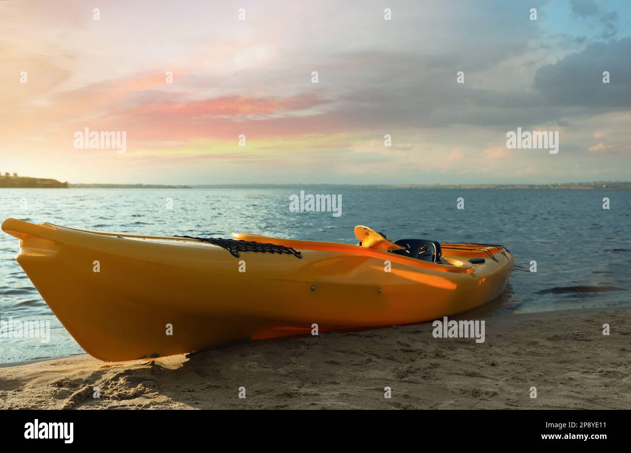 Magnifique kayak jaune moderne sur la plage près de la rivière Banque D'Images Magnifique kayak jaune moderne sur la plage près de la rivière Banque D'Images