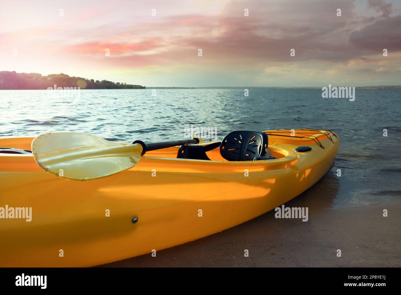 Magnifique kayak jaune moderne avec paddle sur la rivière Banque D'Images Magnifique kayak jaune moderne avec paddle sur la rivière Banque D'Images