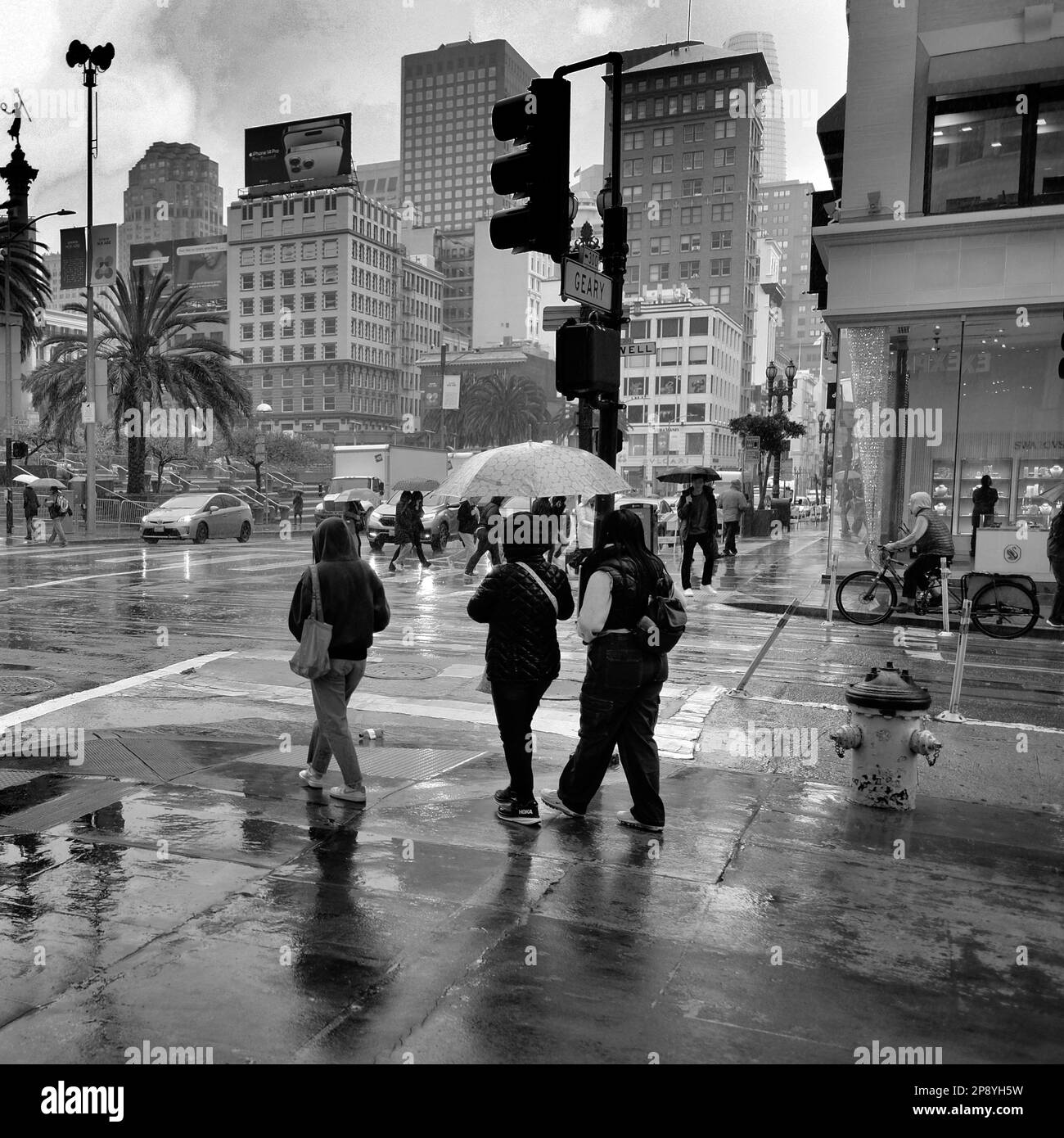 Piétons et touristes dans la pluie dans le centre-ville de San Francisco, Californie; personnes dans les conditions de pluie et le temps humide visite sur le trottoir et la rue Banque D'Images