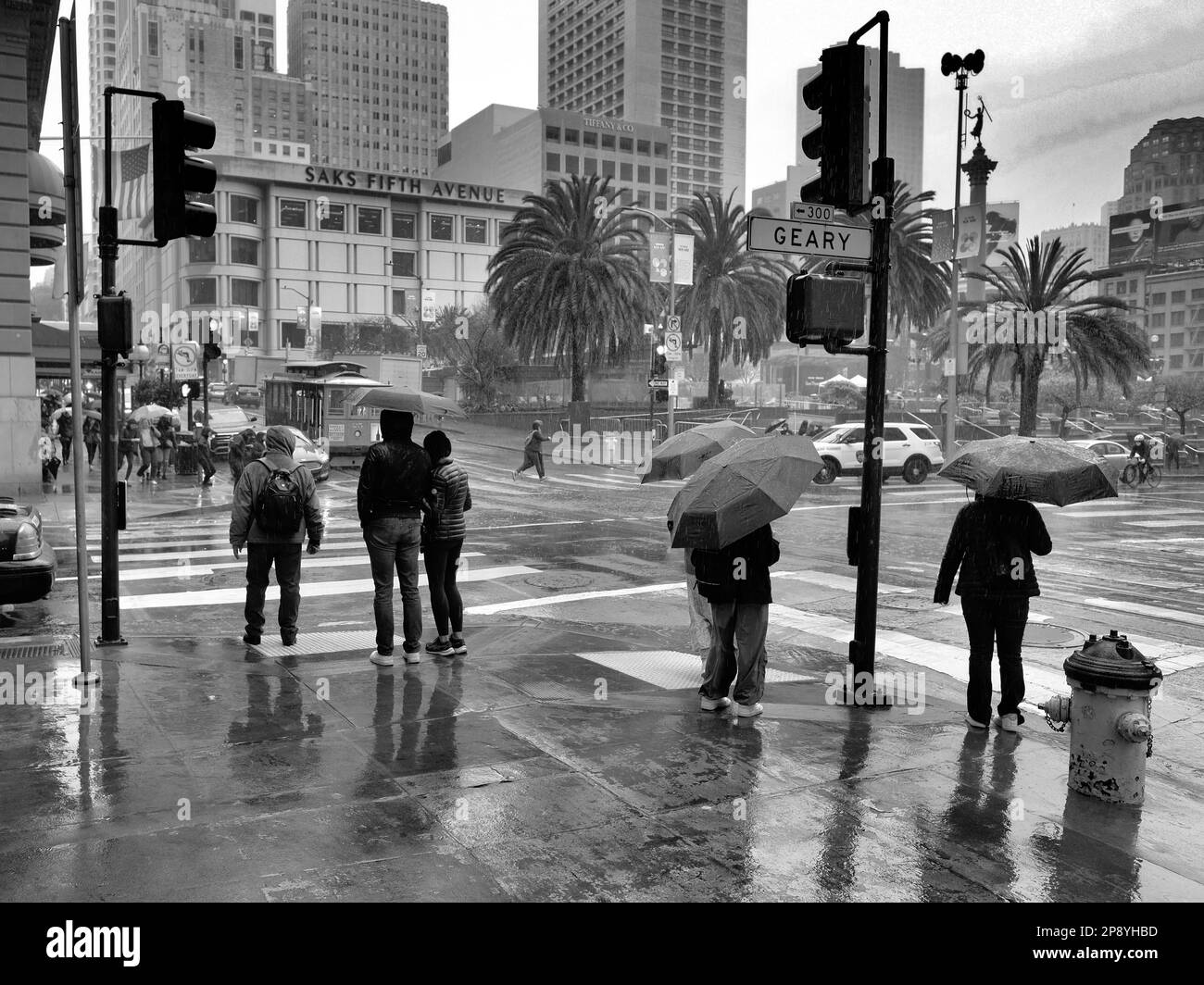 Piétons et touristes dans la pluie dans le centre-ville de San Francisco, Californie; personnes dans les conditions de pluie et le temps humide visite sur le trottoir et la rue Banque D'Images