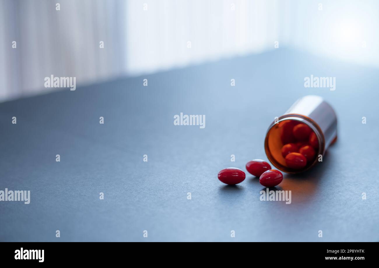 Capsules rouges et bouteille de médicament en plastique brun. La codéine et la guaifenesin capsules pilules pour soulager la toux. Toussez des médicaments. Opioïdes ou stupéfiants Banque D'Images