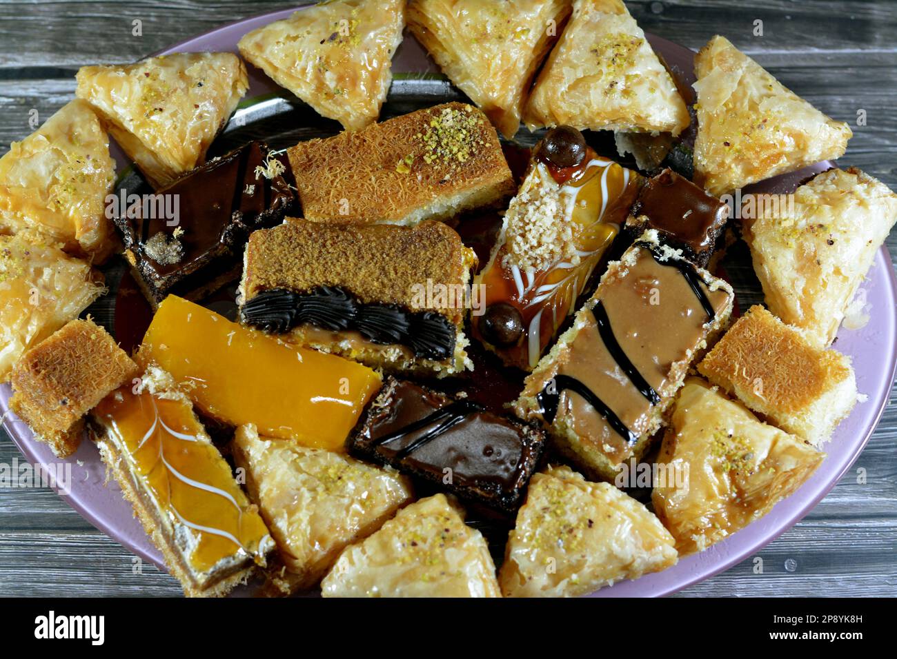 Desserts du Ramadan oriental et pâtisseries de Konafa couvertes de compote de mangue, Kunafa farci de fromage crémeux, Konafa de crème fouettée au chocolat, Ba Banque D'Images