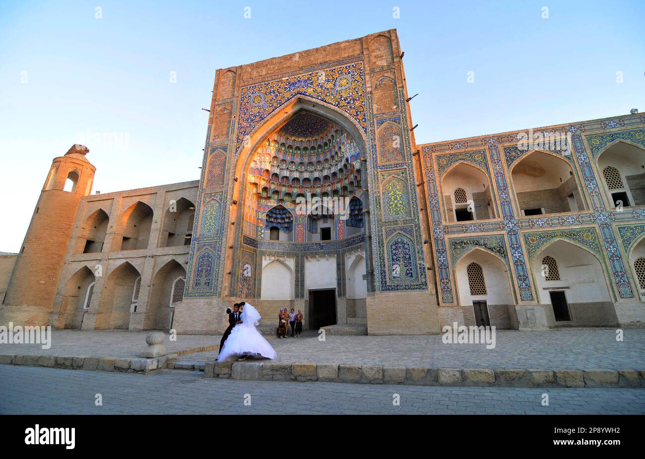Des jeunes Ouzbeks se sont emparés dans une séance photo en face de la Madrassah Abdulaziz Khan, dans la vieille ville de Boukhara, en Ouzbékistan. Banque D'Images