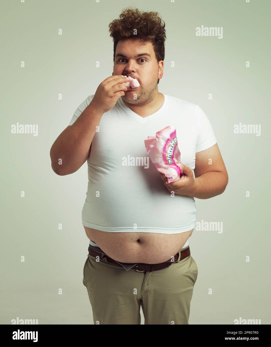 Mon diététicien m'a dit que je devais manger des aliments plus légers. un  homme en surpoids a mis des guimauves dans sa bouche Photo Stock - Alamy