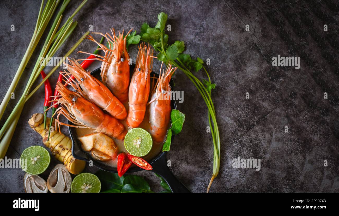 Soupe de crevettes sur un bol à soupe de fruits de mer avec herbes et épices thaïlandaises, crevettes chaudes et aigres sauce au curry citron lime galangal rouge Chili aux champignons de paille Banque D'Images Soupe de crevettes sur un bol à soupe de fruits de mer avec herbes et épices thaïlandaises, crevettes chaudes et aigres sauce au curry citron lime galangal rouge Chili aux champignons de paille Banque D'Images