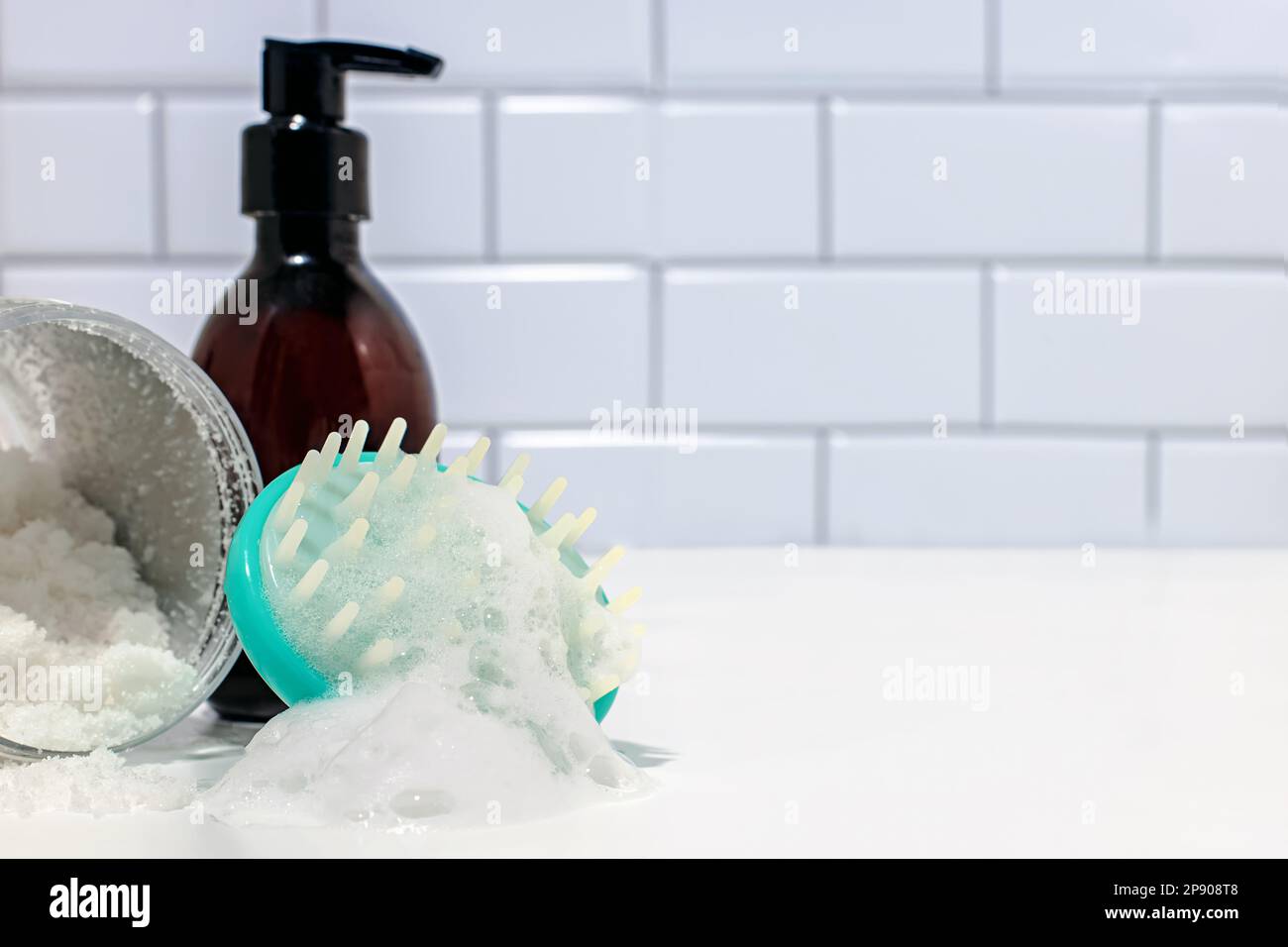 Kit de nettoyage des cheveux, brosse de nettoyage du cuir chevelu avec mousse et une bouteille de shampooing dans la salle de bains Banque D'Images
