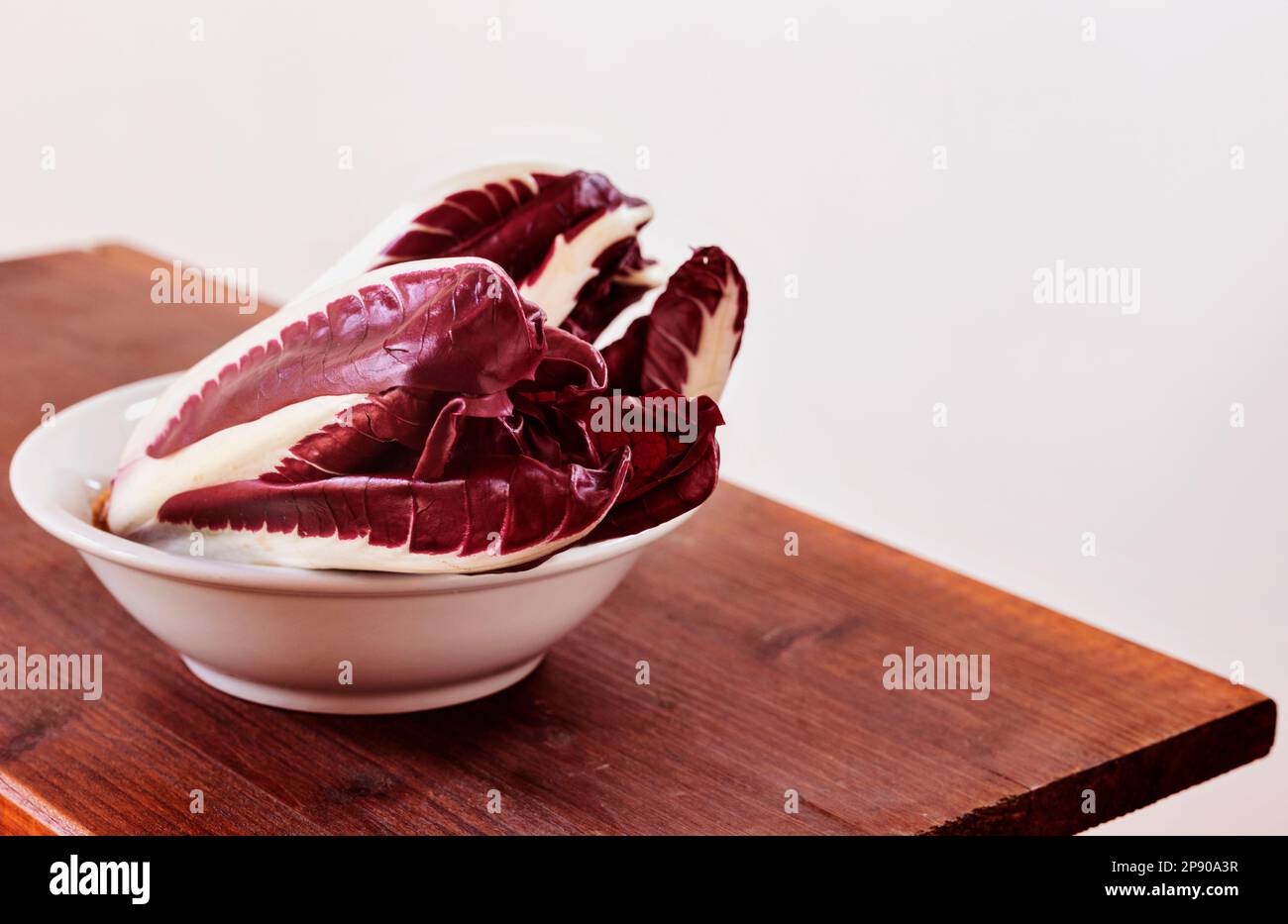 Radicchio, chicorée de feuilles rouges, chicorée italienne dans un bol blanc , utilisation commune dans la cuisine italienne Banque D'Images