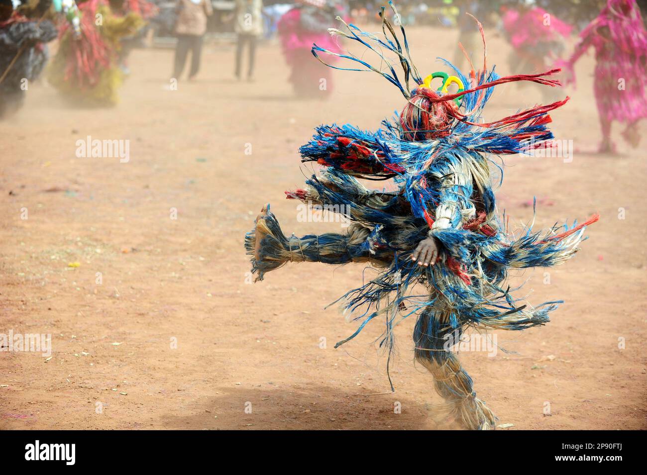 Un masque en fibre coloré qui exécute une danse frétique au Festival Festima à Dedougou, Burkina Faso Banque D'Images