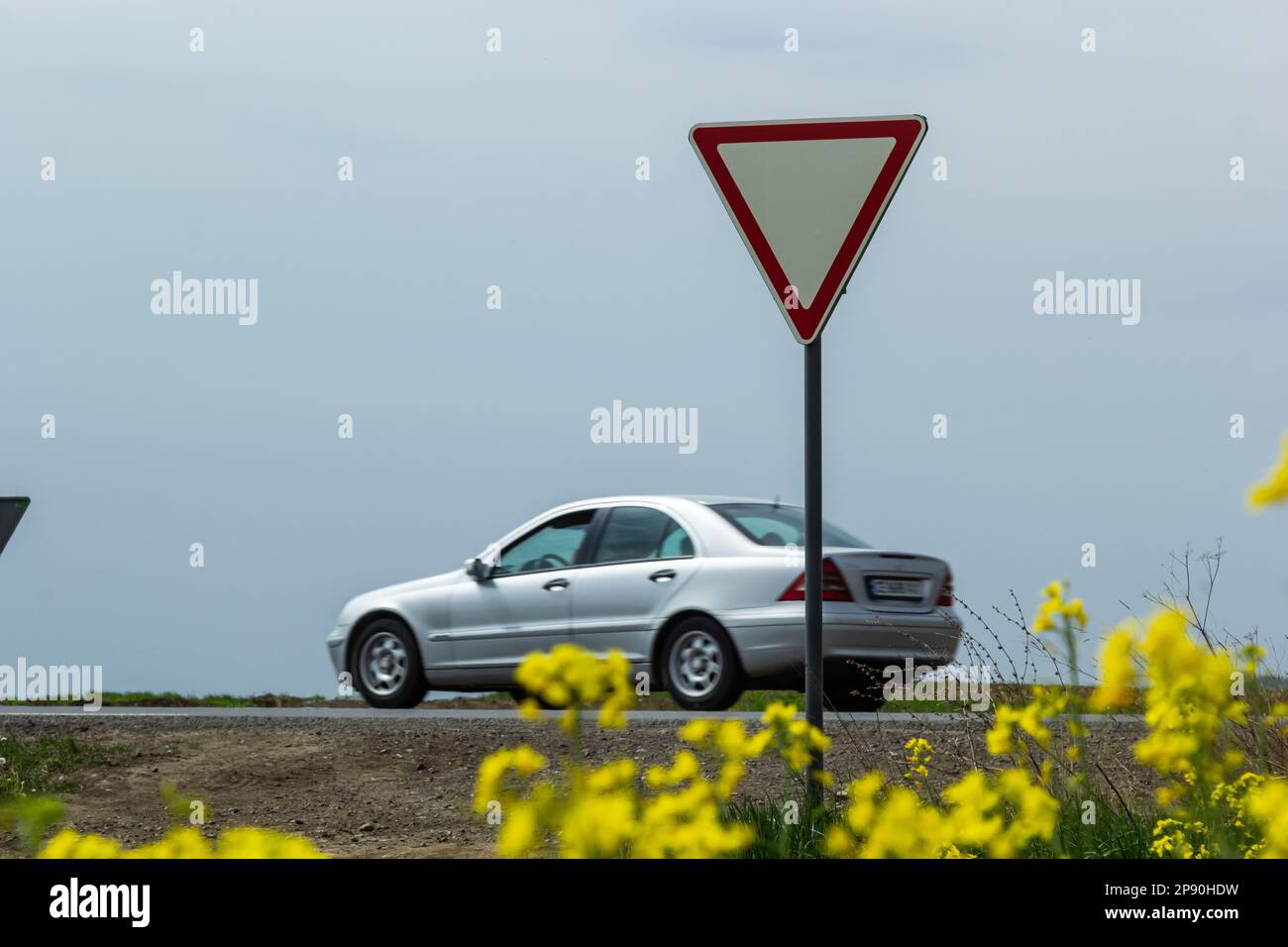 Le panneau laisse place au conducteur en sortant de l'autoroute à une intersection rurale sur le fond d'une voiture qui passe. Banque D'Images