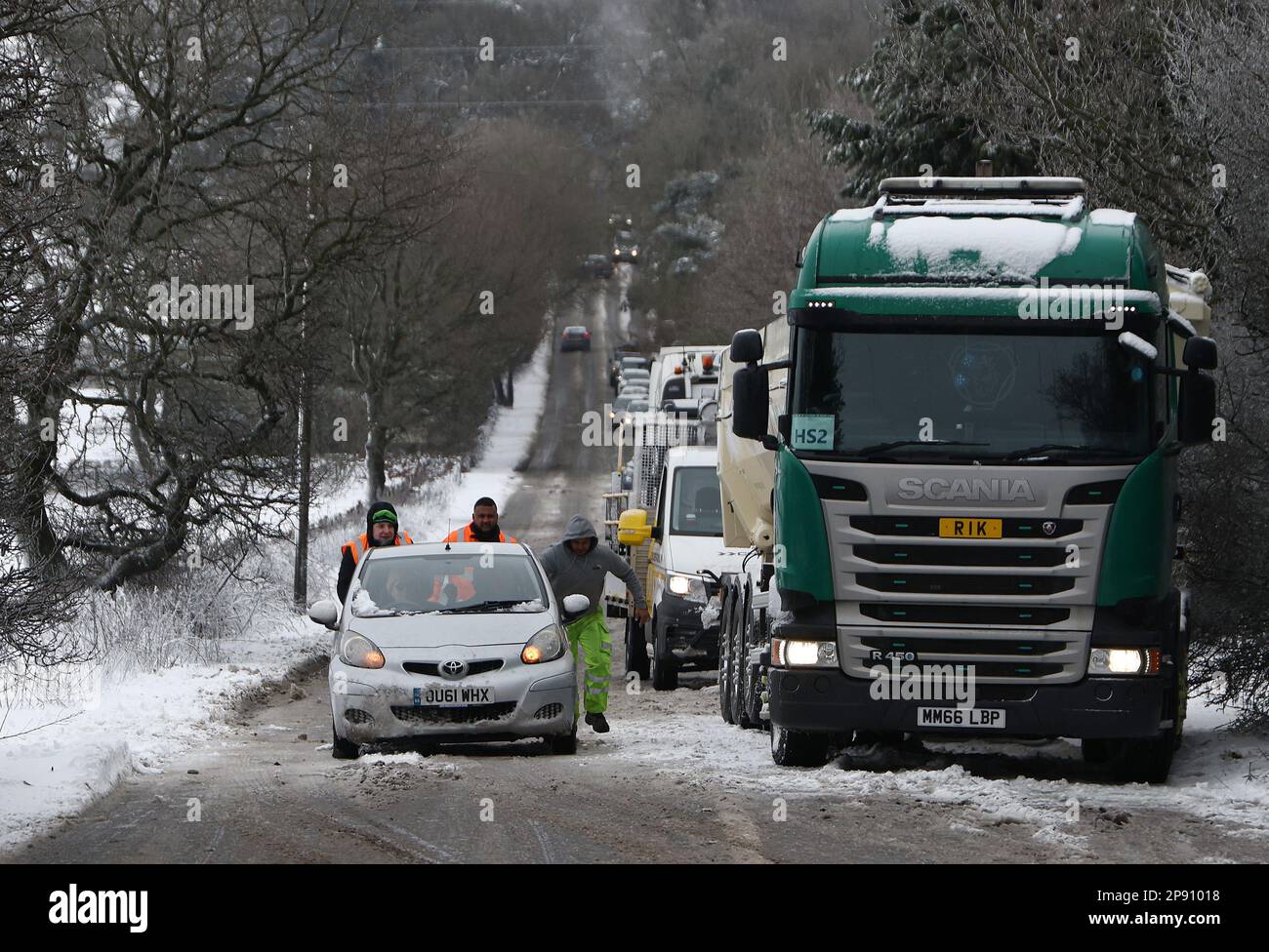 Coalville, Leicestershire, Royaume-Uni. 10th mars 2023. Météo au Royaume-Uni. Les hommes poussent une voiture sur une colline enneigée et verglacée. Les conditions de gel et les vents violents dans une grande partie du Royaume-Uni affectent les routes et les chemins de fer, avec des centaines d'écoles fermées. Credit Darren Staples/Alay Live News. Banque D'Images